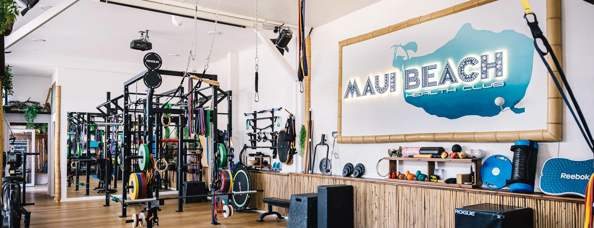 Trainingsfläche des Maui Beach Health Club mit dem Logo an der Wand