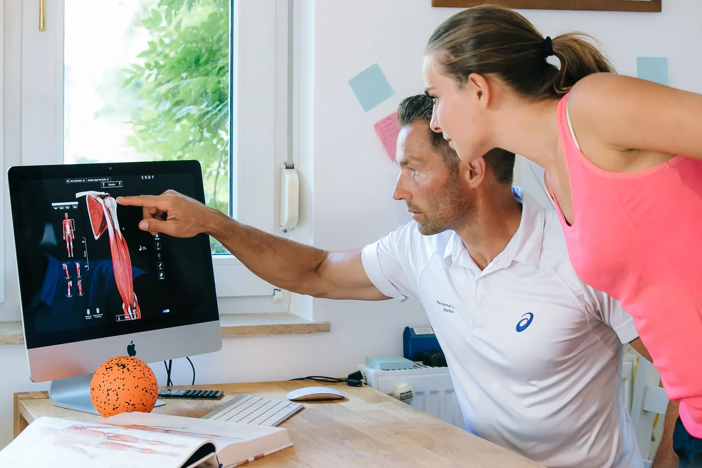 Stefan Hornburg bespricht mit einer Kundin ihren Trainingsplan am Bildschirm