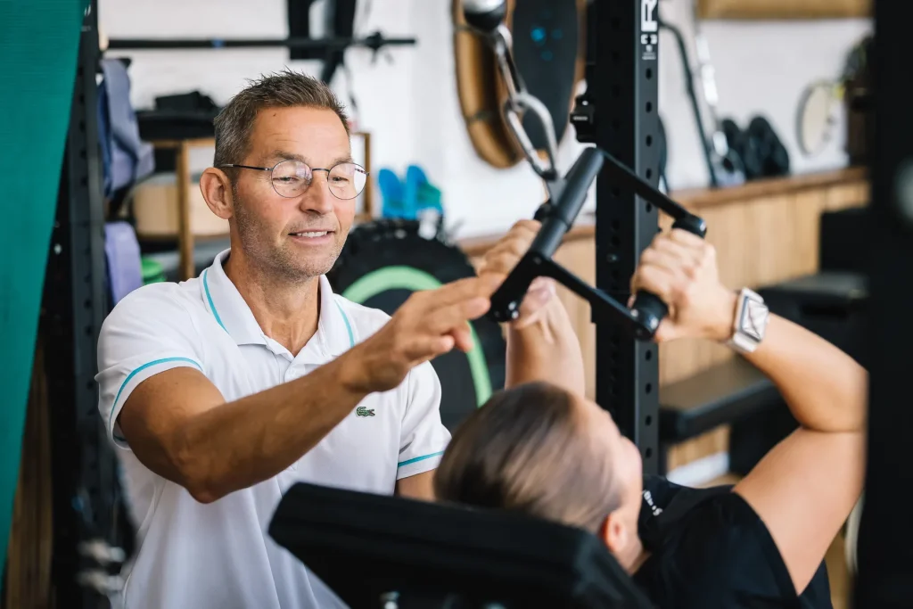 Stefan Hornburg begleitet eine Kundin beim Krafttraining im Studio