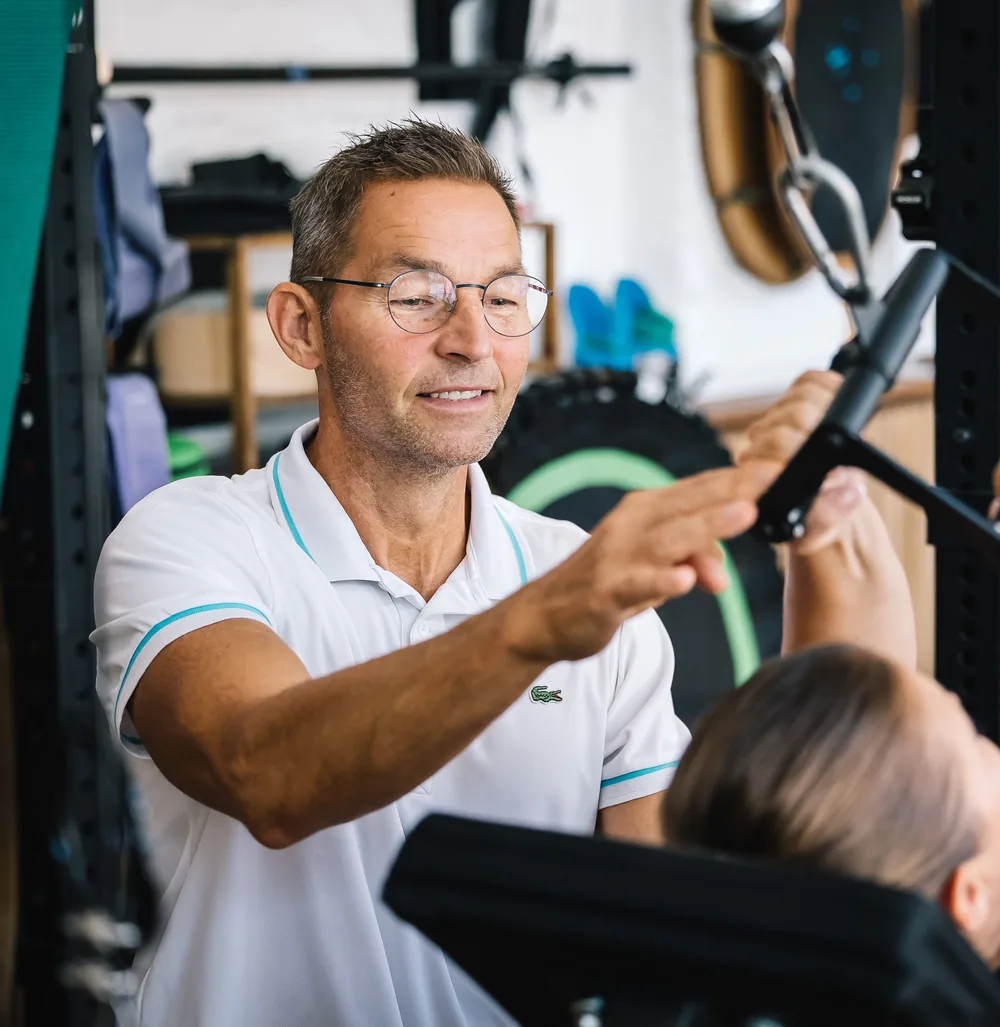 Stefan Hornburg begleitet eine Kundin beim Krafttraining im Studio